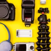 Top view flatlay of summer vacation photographer kit on yellow background